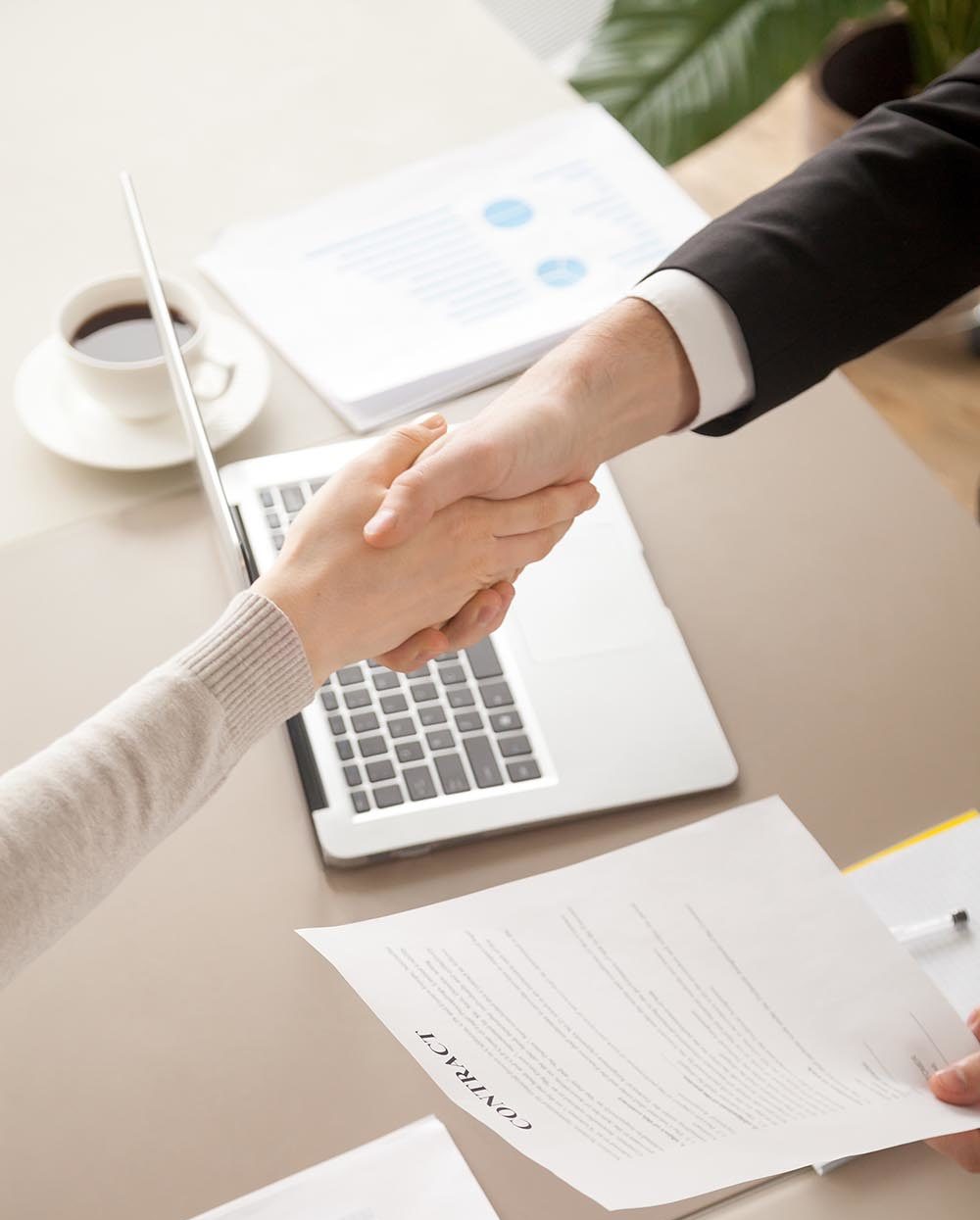 Man and woman shaking hands over an application document