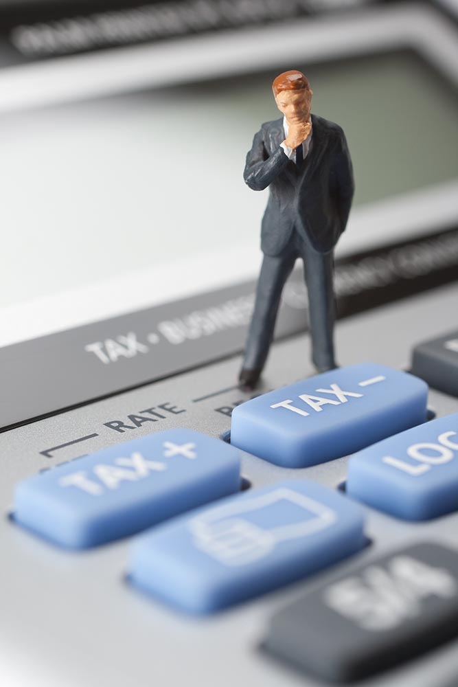 Accountant figurine confused on a calculator