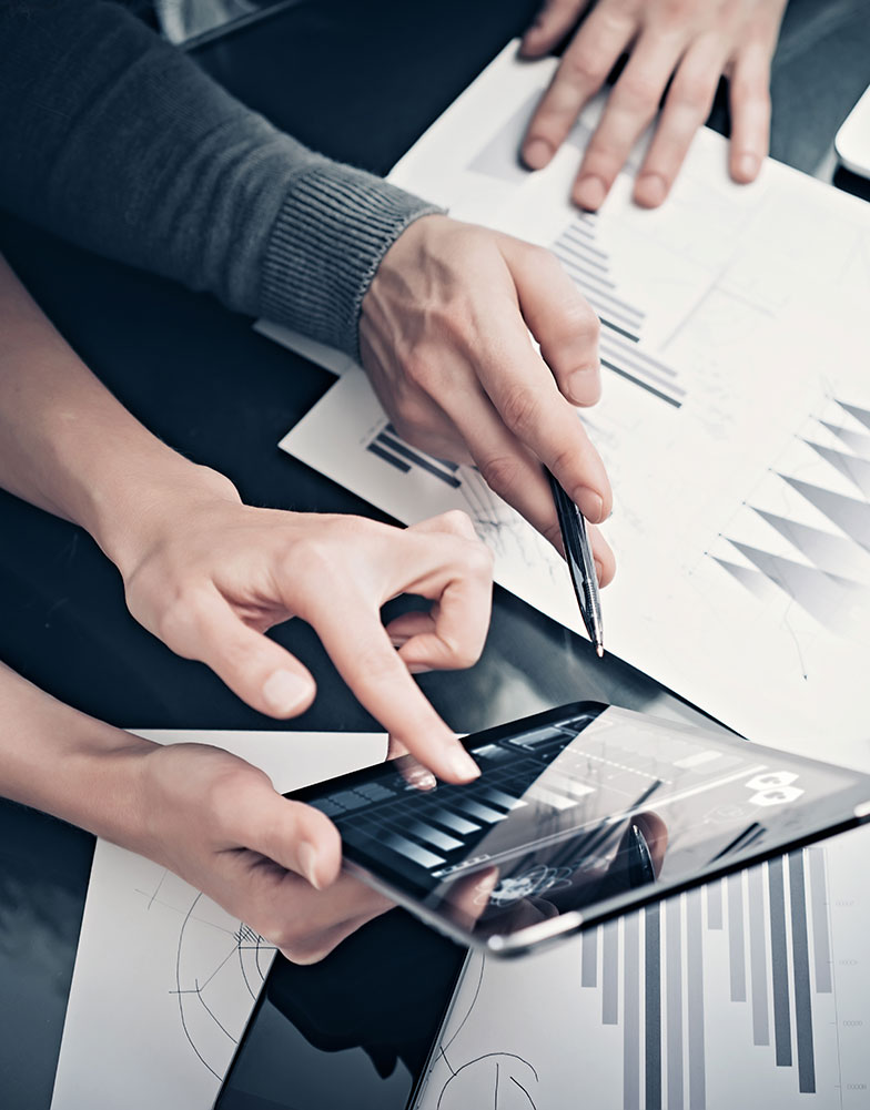 two business men looking over graphs on a tablet