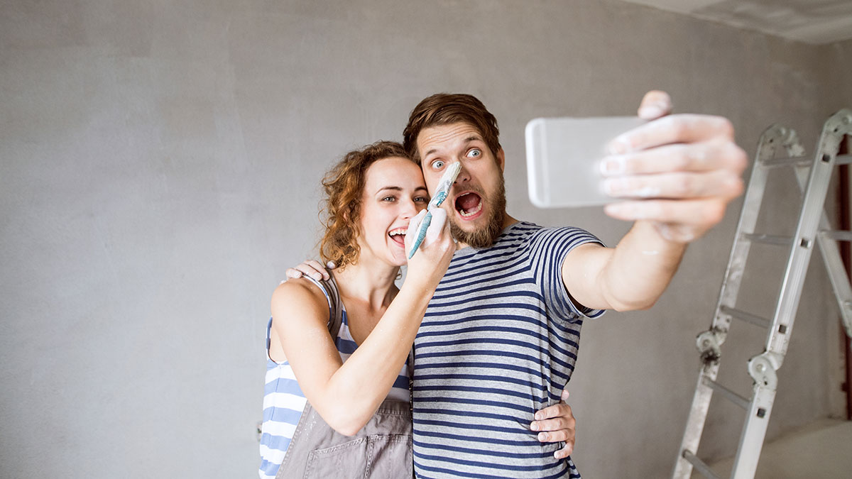 A happy couple making home improvements taking of selfie