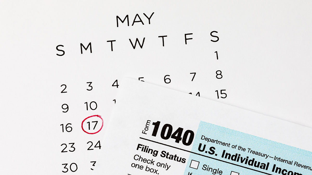 Calendar with May 17th circled in red pen to indicate new tax deadline 1040 form below