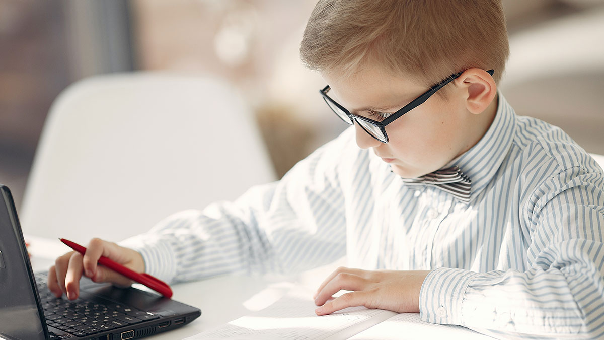 young kid using a calculator doing taxes wearing glasses and a bowtie