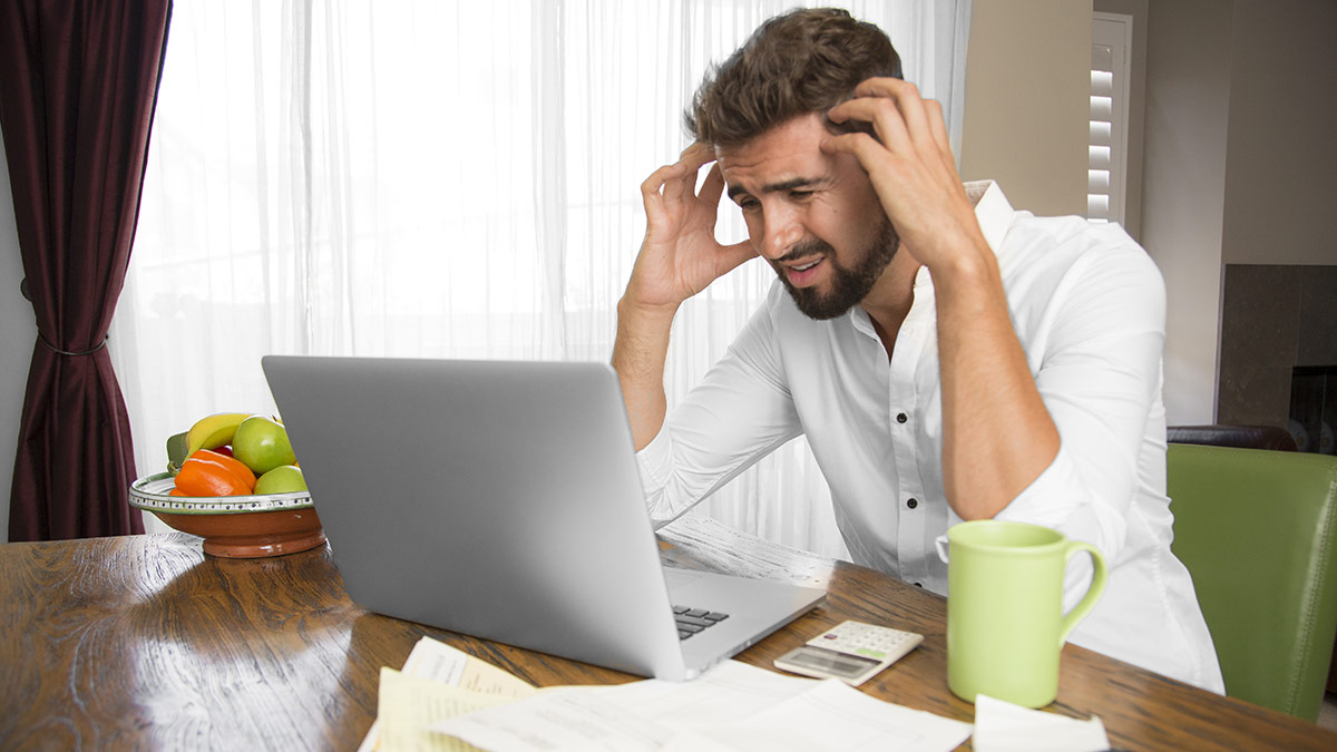 man at a laptop stressed about a mistake he's made