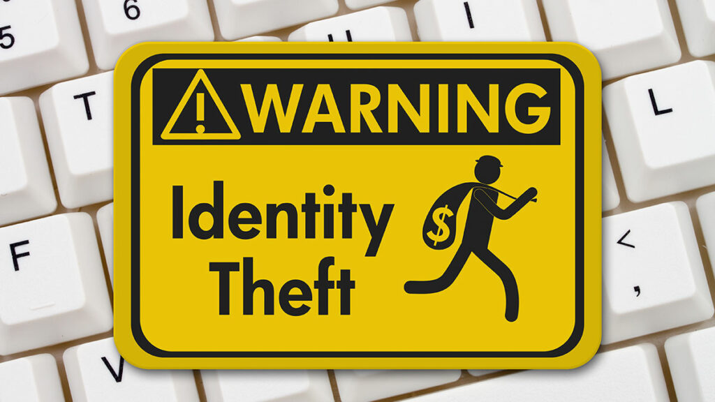 Identity theft warning sign cartoon man running across a keyboard with a money bag