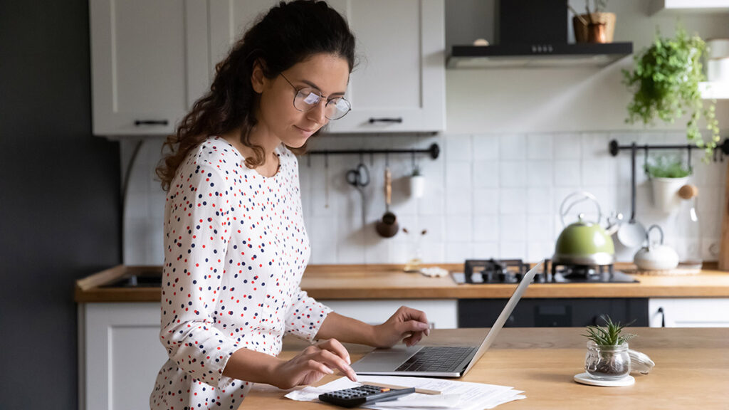 Woman working on Home Business accounting at her kitchen counter