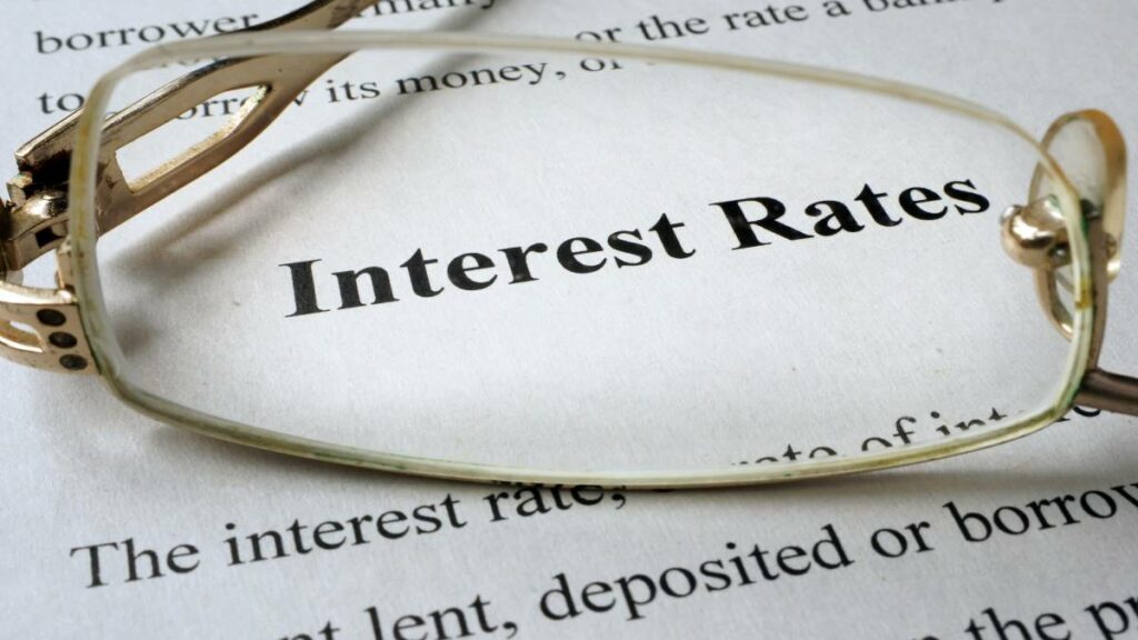 document on a table with the words Interest Rates showing through a glasses lense
